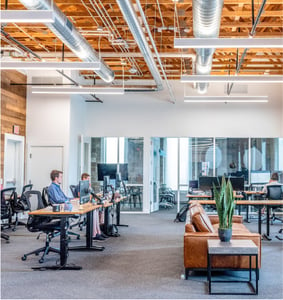 picture of an office, with a few people working at desks